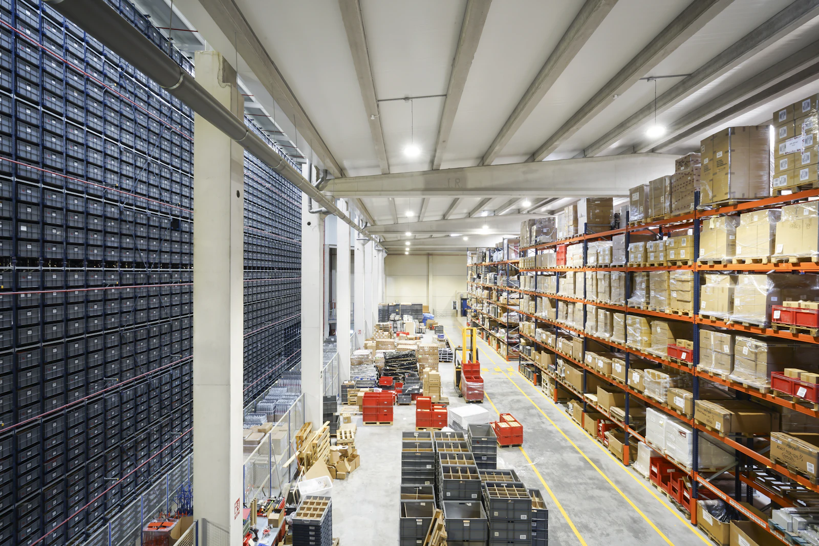 A warehouse aisle running between full-height pallet racking